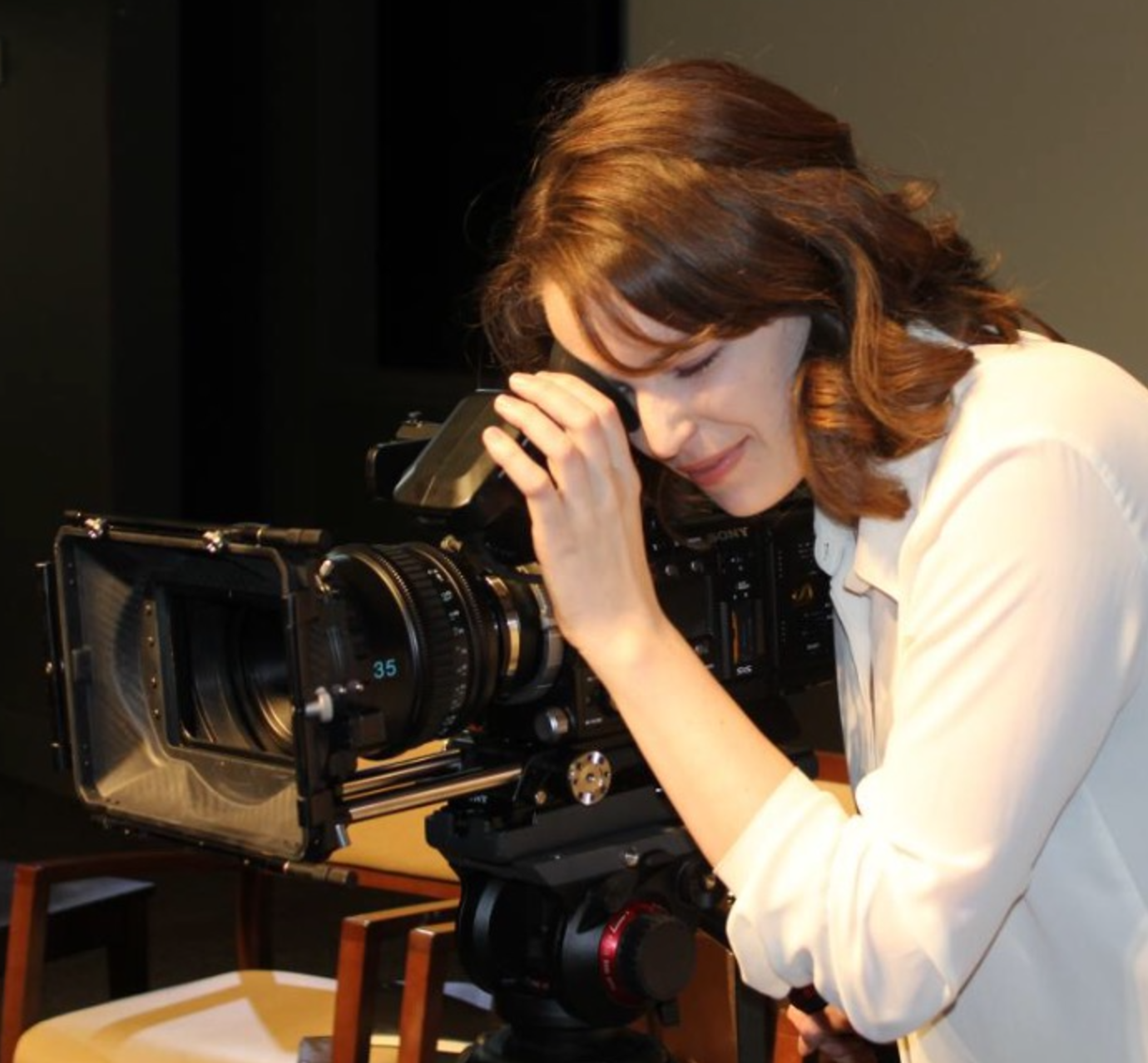 Lauren looking through the viewfinder of a professional motion-picture camera during her previous career in film.